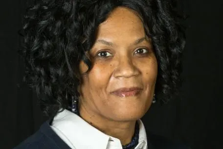 Labor Leader Vonda McDaniel - Headshot, black curly hair, black sweatshirt over a white collared buttondown